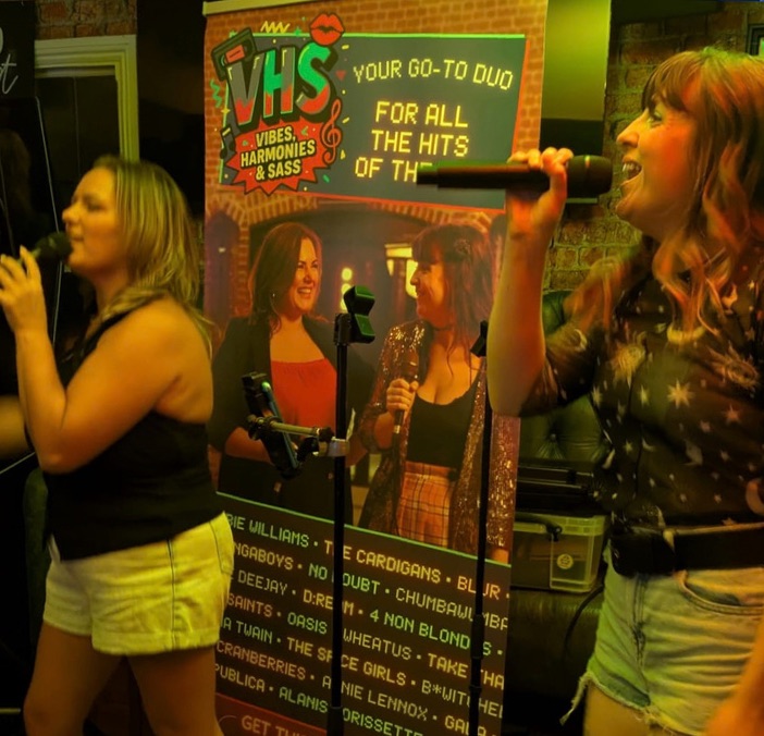 VHS singing next to their banner